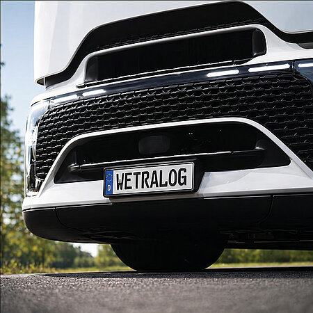 Nahaufnahme der Front eines weißen Wetralog-Lkw mit Kennzeichen „WETRALOG“.