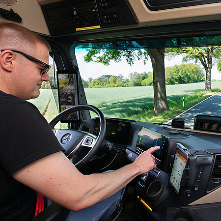 Wetralog-Fahrer bedient ein digitales Navigationssystem in einer modernen Lkw-Fahrerkabine.